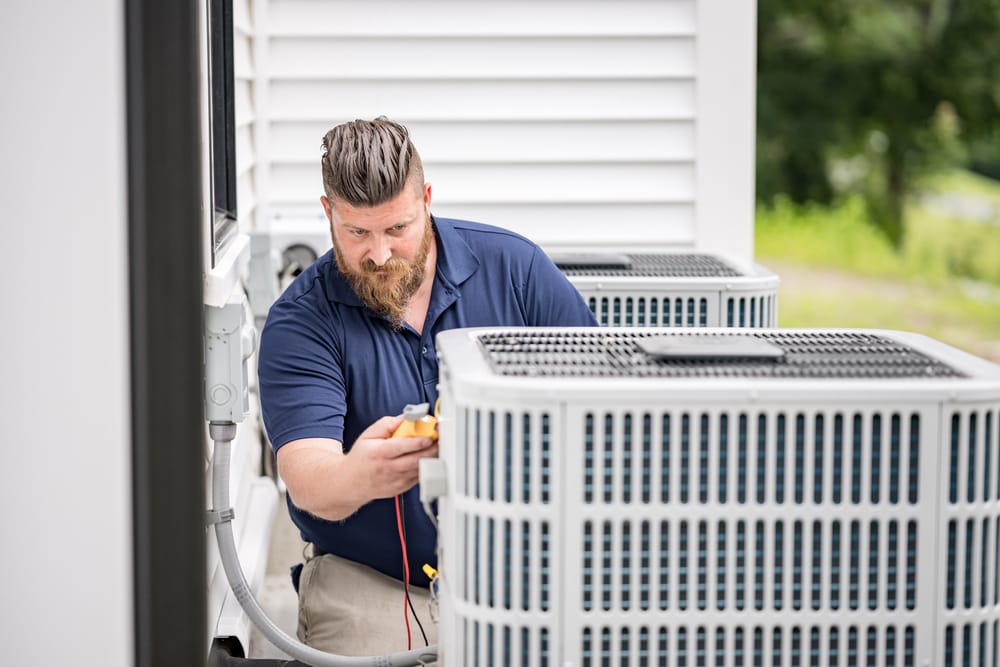HVAC tech inspecting an air conditioning unit.