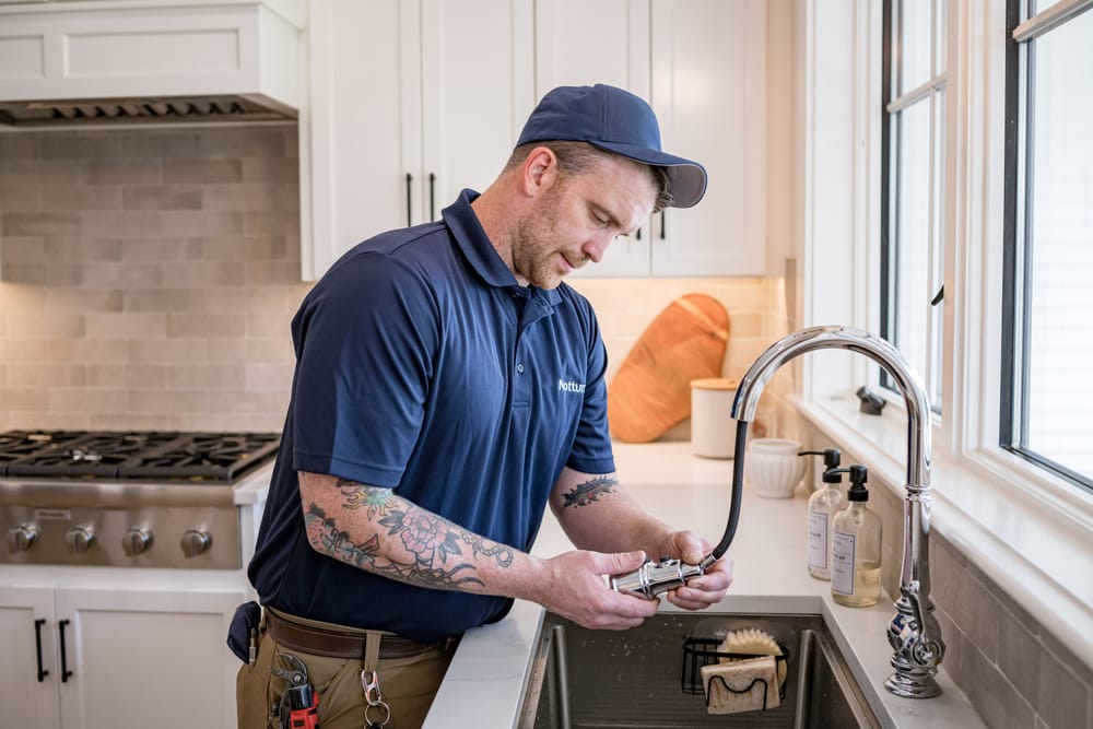 Plumber holding sink head during a drain cleaning service.