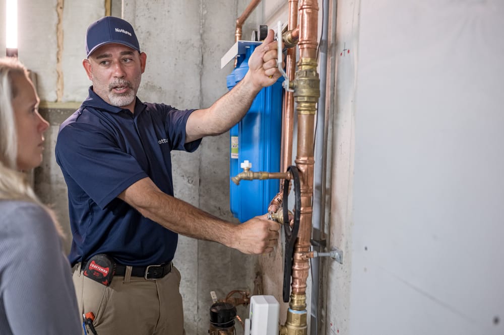 Tech showing off a whole-house water filtration system.