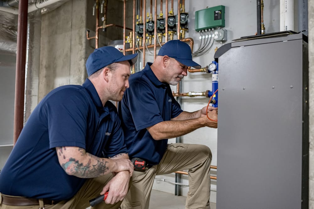 Two technicians working on furnace.