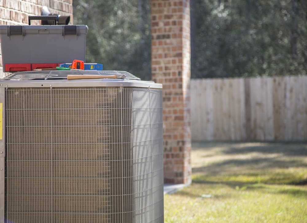 Outdoor air conditioning unit with tools on top of it