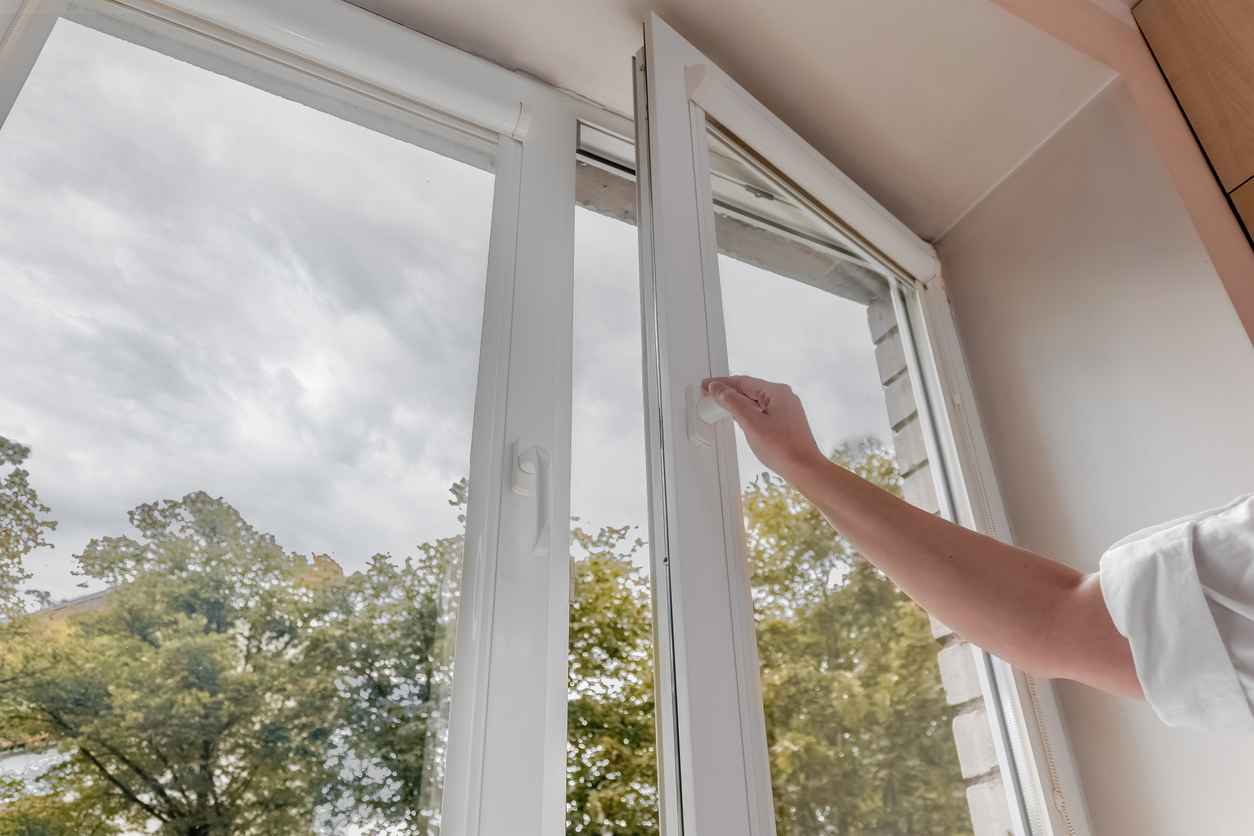 Hand opening windows in house to let in fresh air, room ventilation concept