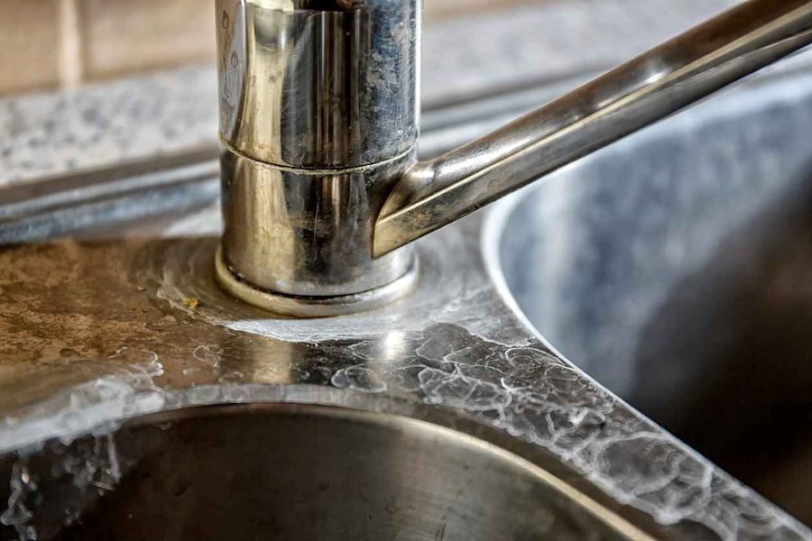 Hard water scale on kitchen sink and faucet