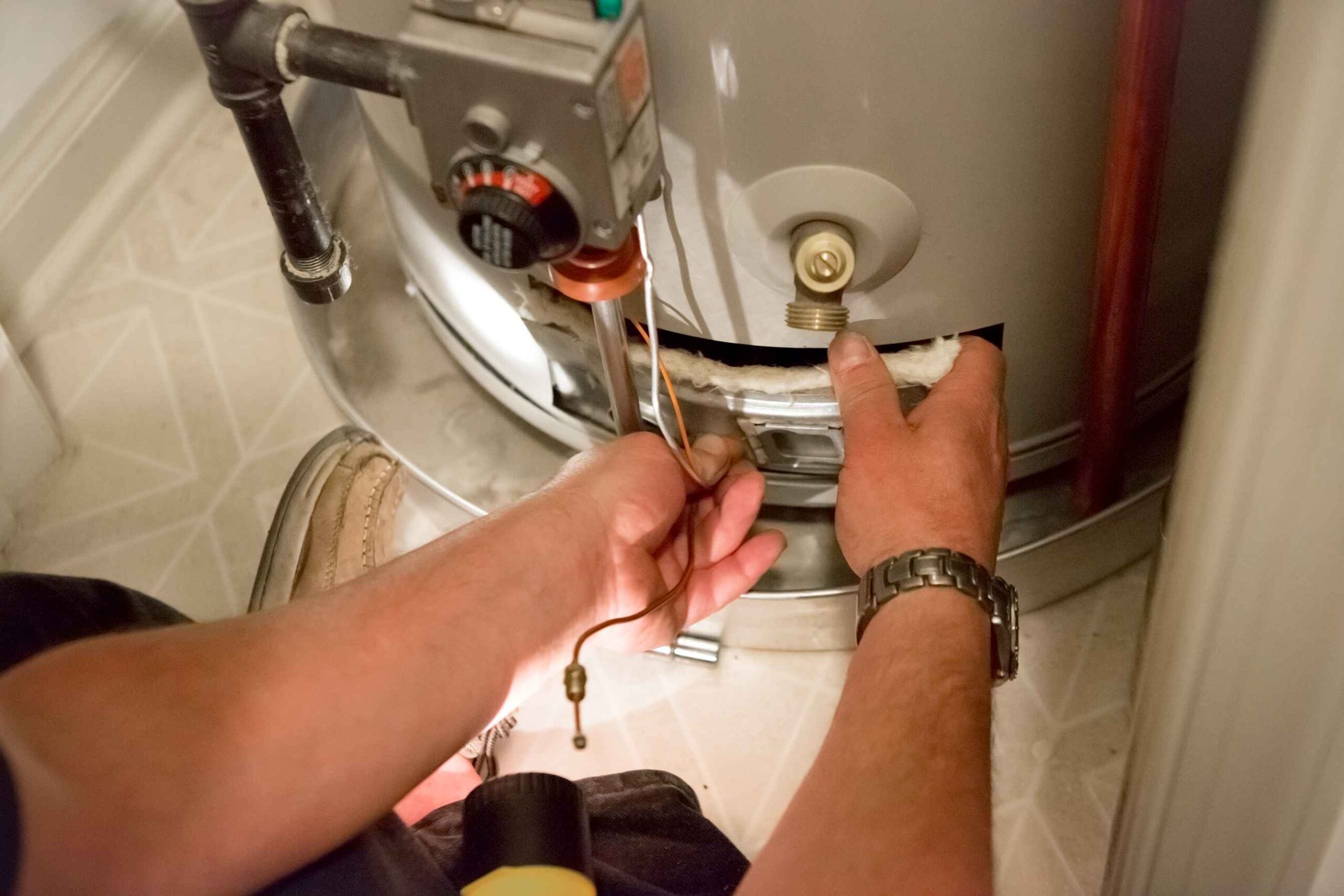 Plumber inspecting a water heater to see if any repairs are needed
