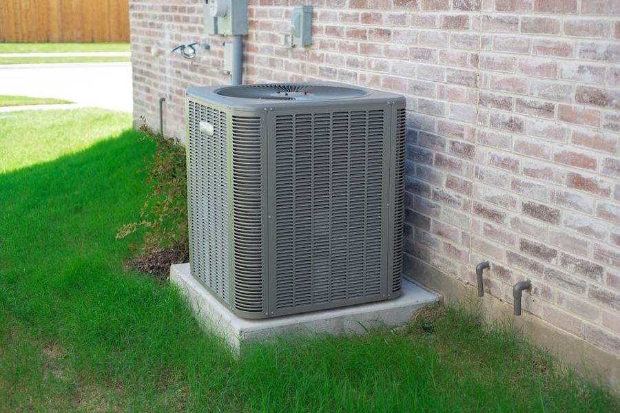 Outdoor air conditioning unit next to a brick house