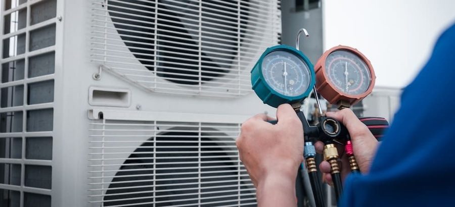 HVAC technician performing maintenance on an outdoor air conditioning unit